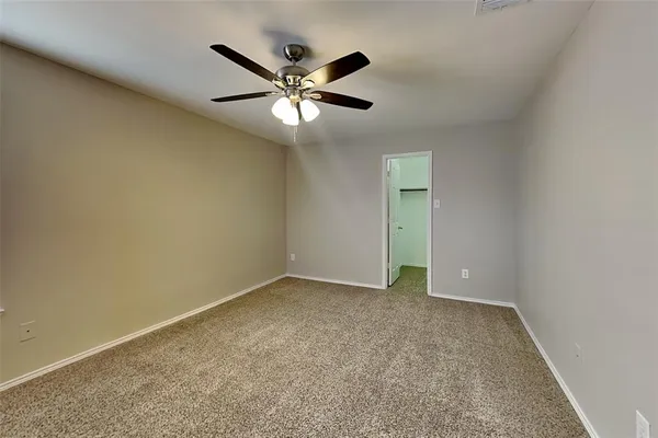 an empty room with closet area and fan