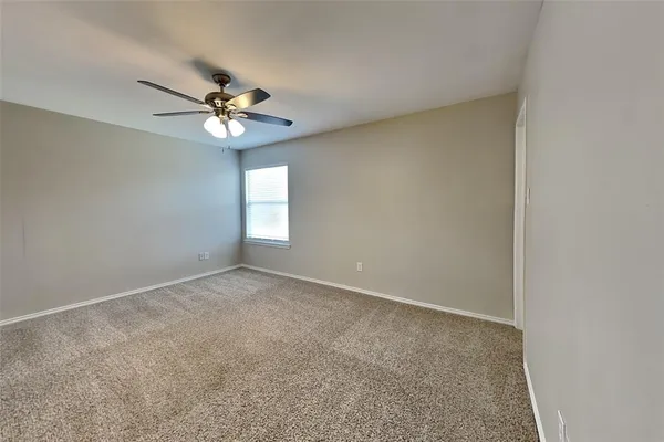 an empty room with a window and a ceiling fan
