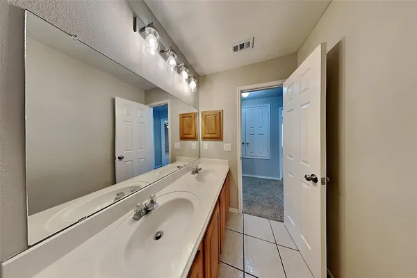 a bathroom with a double vanity sink and mirror with shower