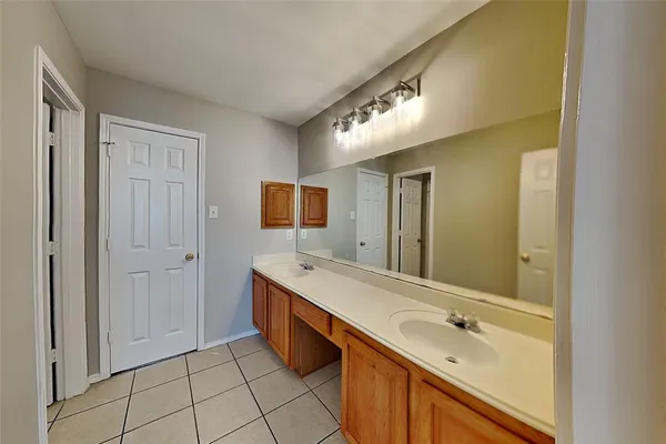 a spacious bathroom with a double vanity sink a mirror and a bathtub