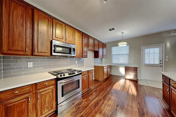 a kitchen with granite countertop stainless steel appliances and wooden cabinets