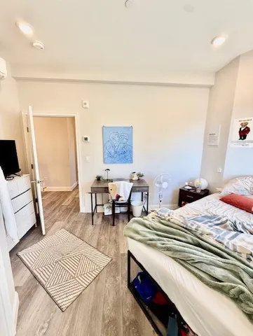 a bedroom with a bed a rug and a dresser