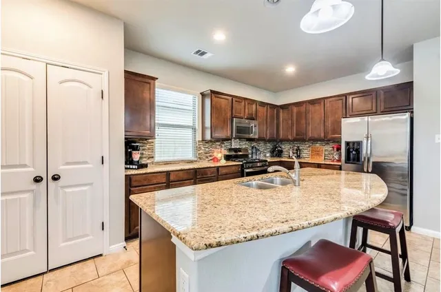 a kitchen with refrigerator and chairs