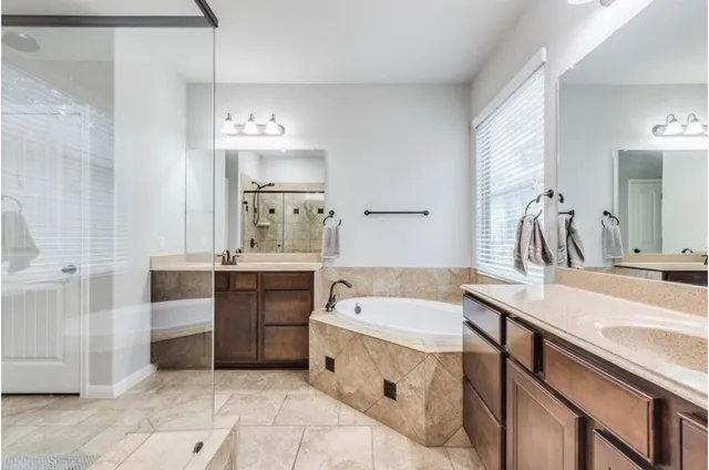 a bathroom with a double vanity sink a mirror and a bathtub