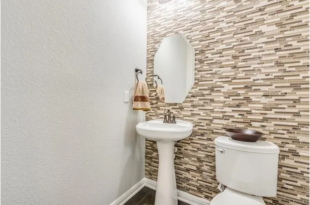 a bathroom with a sink a toilet and mirror