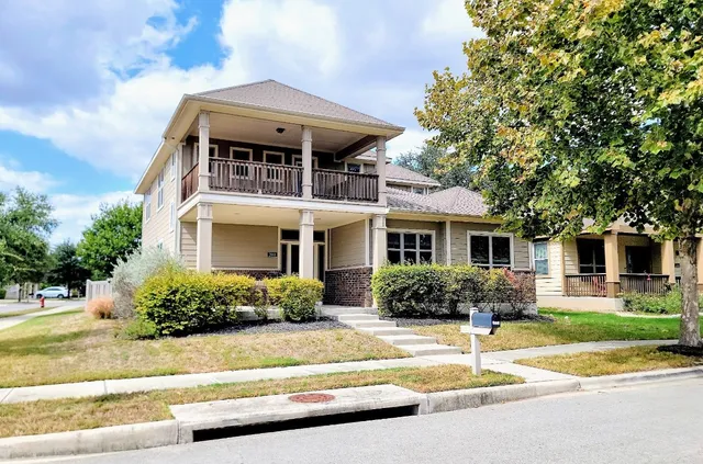 a front view of a house with a yard and potted plants