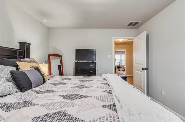 a bedroom with bed and large mirror