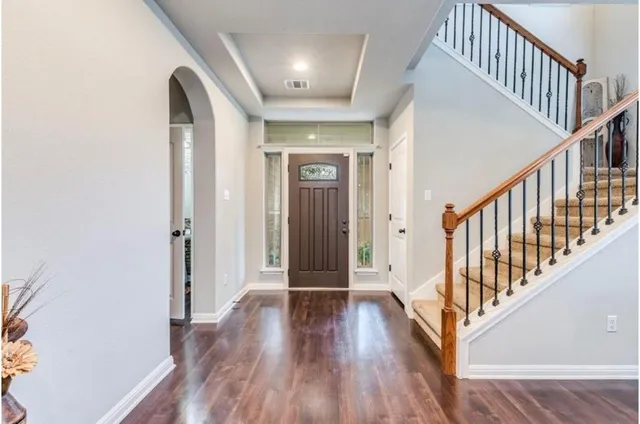 a view of a hallway with wooden floor and entryway
