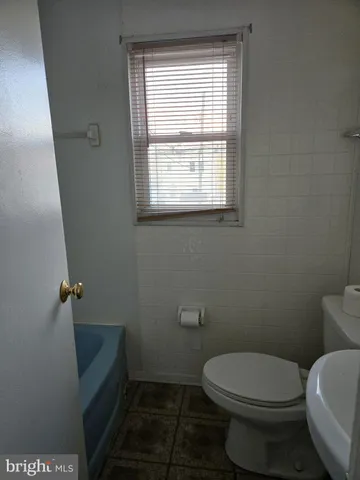 a bathroom with a toilet and a window