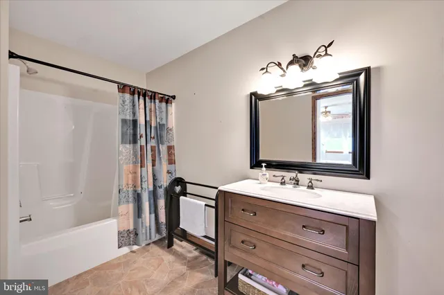 a view of a bathroom with wooden floor and a shower curtain