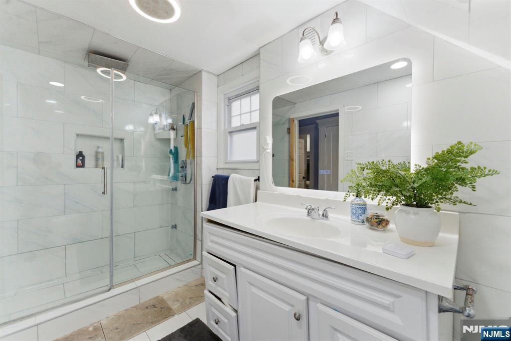 105 Daniel Avenue Rutherford, NJ 07070 - Photo 18 of 38 a bathroom with a shower sink and mirror