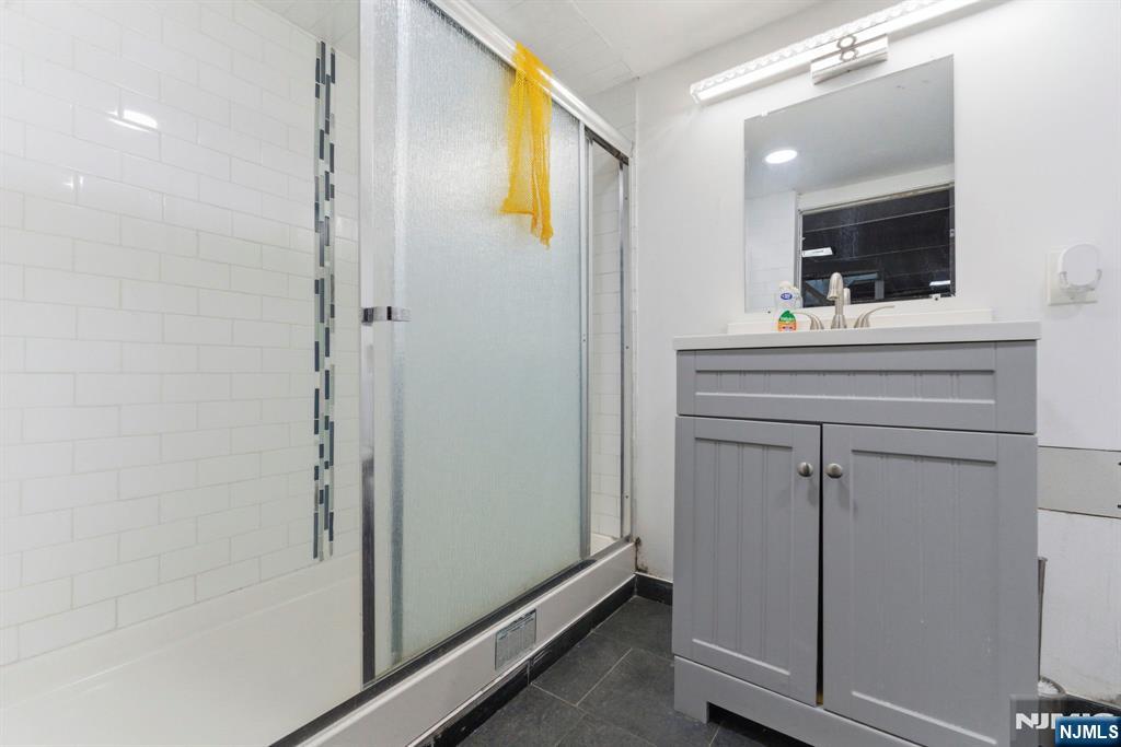 105 Daniel Avenue Rutherford, NJ 07070 - Photo 27 of 38 a bathroom with a shower sink and mirror
