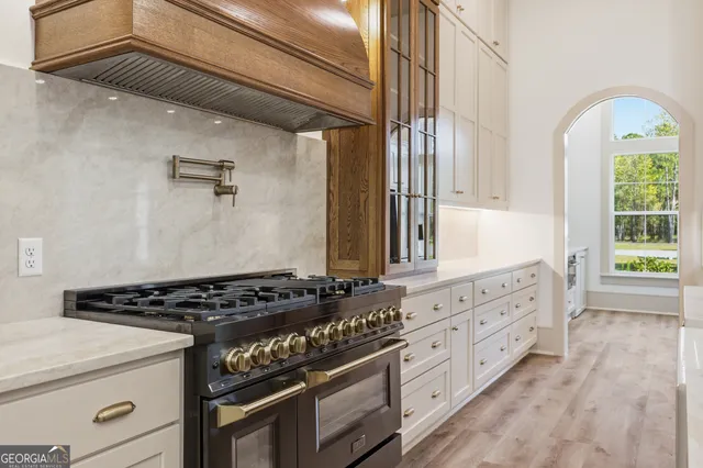 an empty room with wooden floor chandelier fan and windows