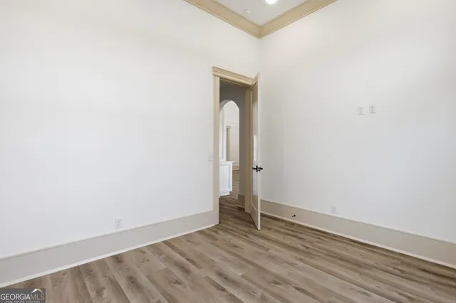 a front view of a house with a garden and trees