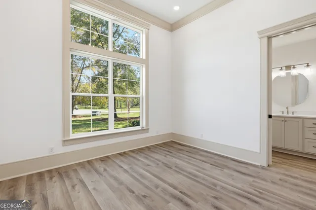 a front view of a house with a garden and trees