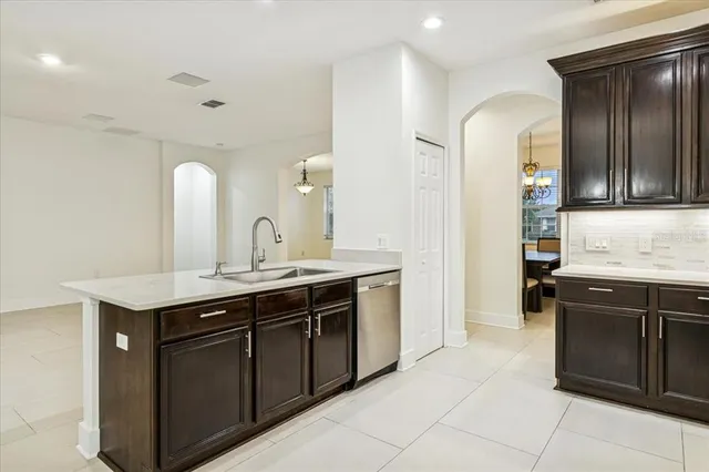 a kitchen with a sink and a stove top oven with wooden cabinets