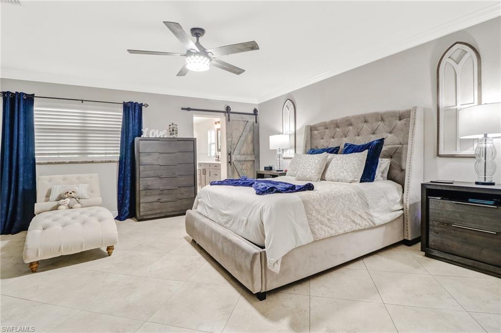 2329 41st Terrace Southwest Naples, FL 34116 - Photo 15 of 33 a bedroom with a large bed and ceiling fan