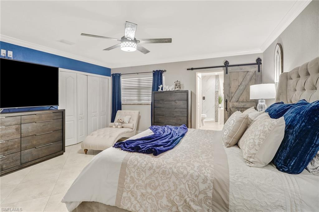 2329 41st Terrace Southwest Naples, FL 34116 - Photo 16 of 33 a bedroom with a bed and a flat screen tv