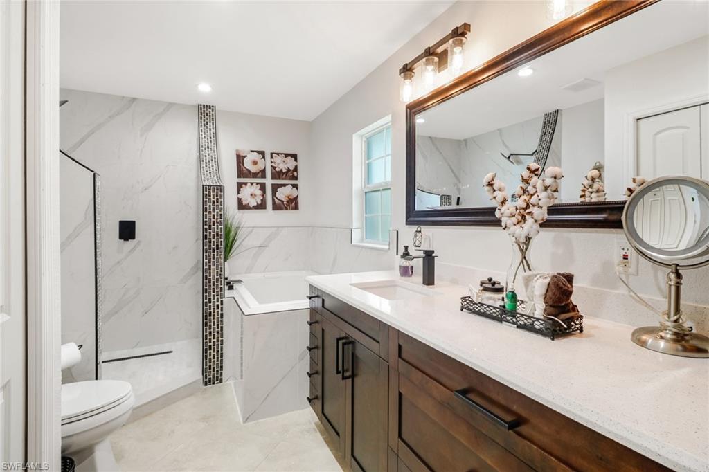 2329 41st Terrace Southwest Naples, FL 34116 - Photo 17 of 33 a bathroom with a double vanity sink toilet and shower