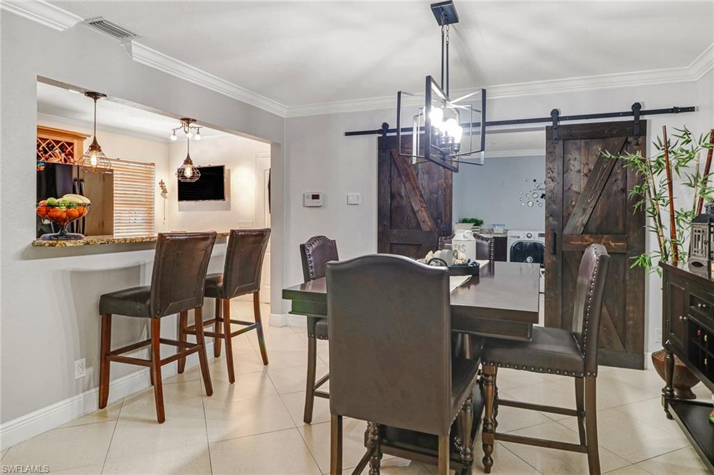 2329 41st Terrace Southwest Naples, FL 34116 - Photo 6 of 33 a view of a dining room with furniture and a chandelier