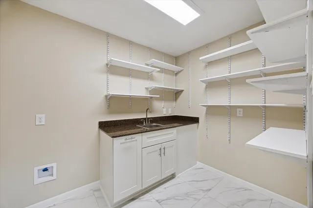 a kitchen with granite countertop a sink cabinets and stainless steel appliances