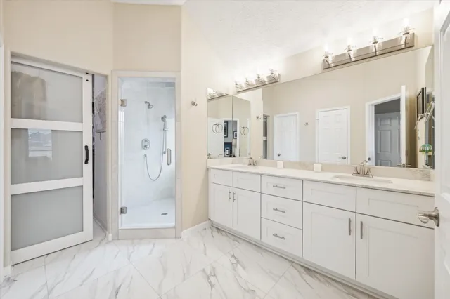 a spacious bathroom with a shower a sink and mirror