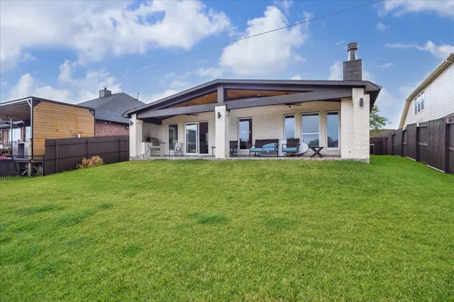 a view of a house with a big yard and large trees