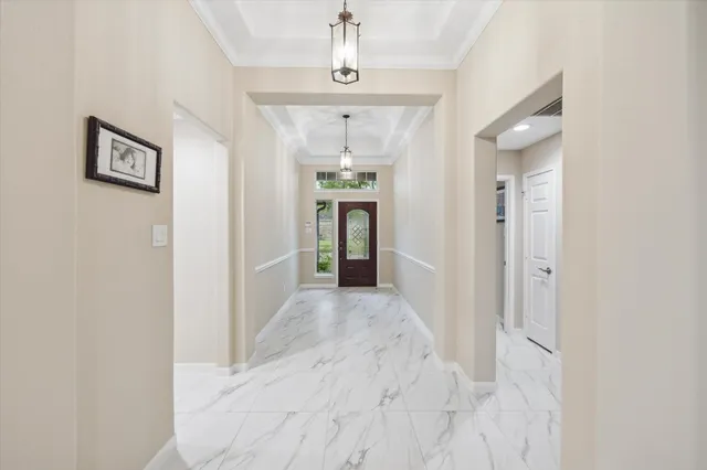 a view of a hallway with wooden floor and chandelier