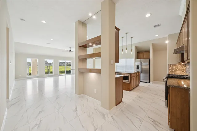 a view of a kitchen with stainless steel appliances granite countertop a refrigerator a sink dishwasher and a stove with wooden floor