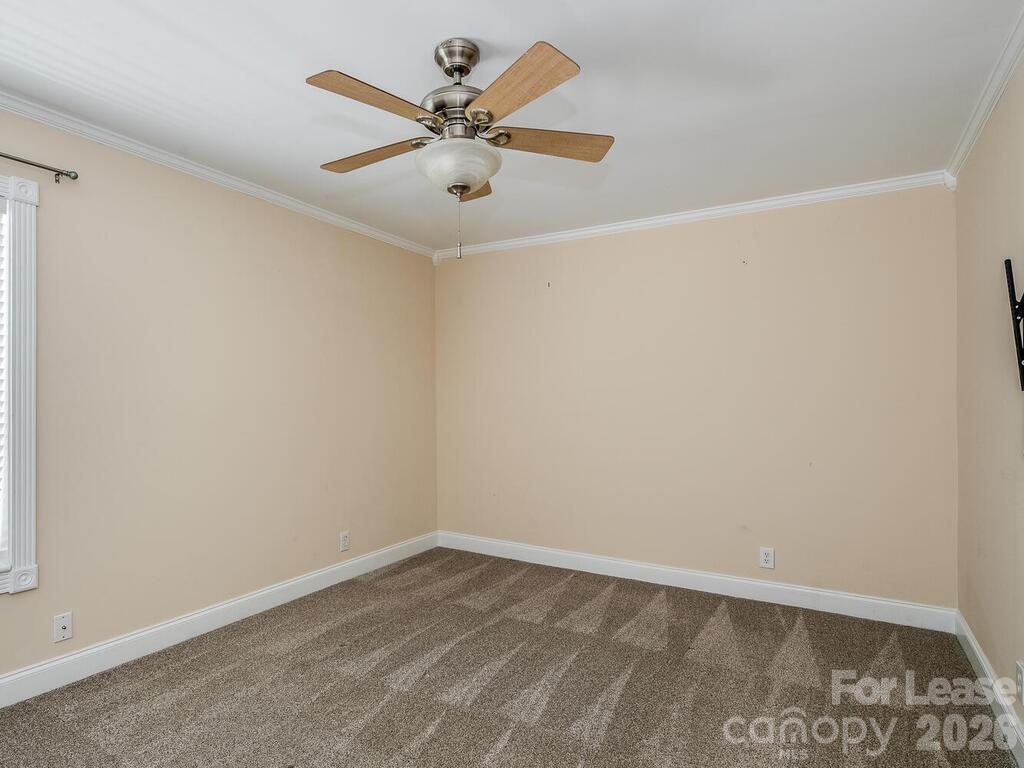 2600 Park Road, Unit D Charlotte, NC 28209 - Photo 16 of 22 an empty room with a window and a ceiling fan