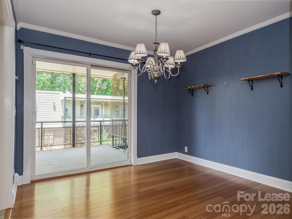 2600 Park Road, Unit D Charlotte, NC 28209 - Photo 7 of 22 a view of an empty room with wooden floor and a window