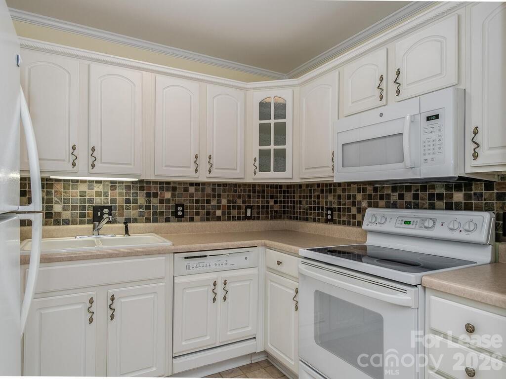 2600 Park Road, Unit D Charlotte, NC 28209 - Photo 8 of 22 a kitchen with white cabinets and white appliances