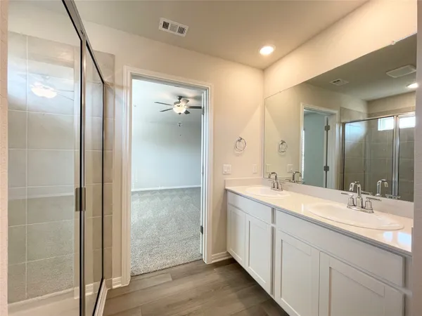 a bathroom with a double vanity sink mirror and shower