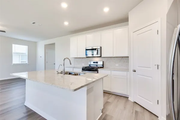 a kitchen with stainless steel appliances granite countertop a sink stove and refrigerator