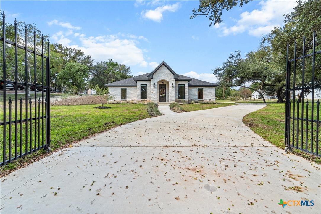 a front view of a house with a yard and trees