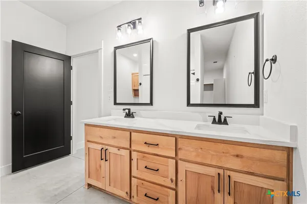 a bathroom with double vanity sinks and a mirror