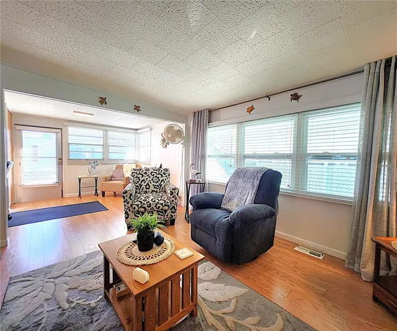 a living room with furniture potted plant and a large window