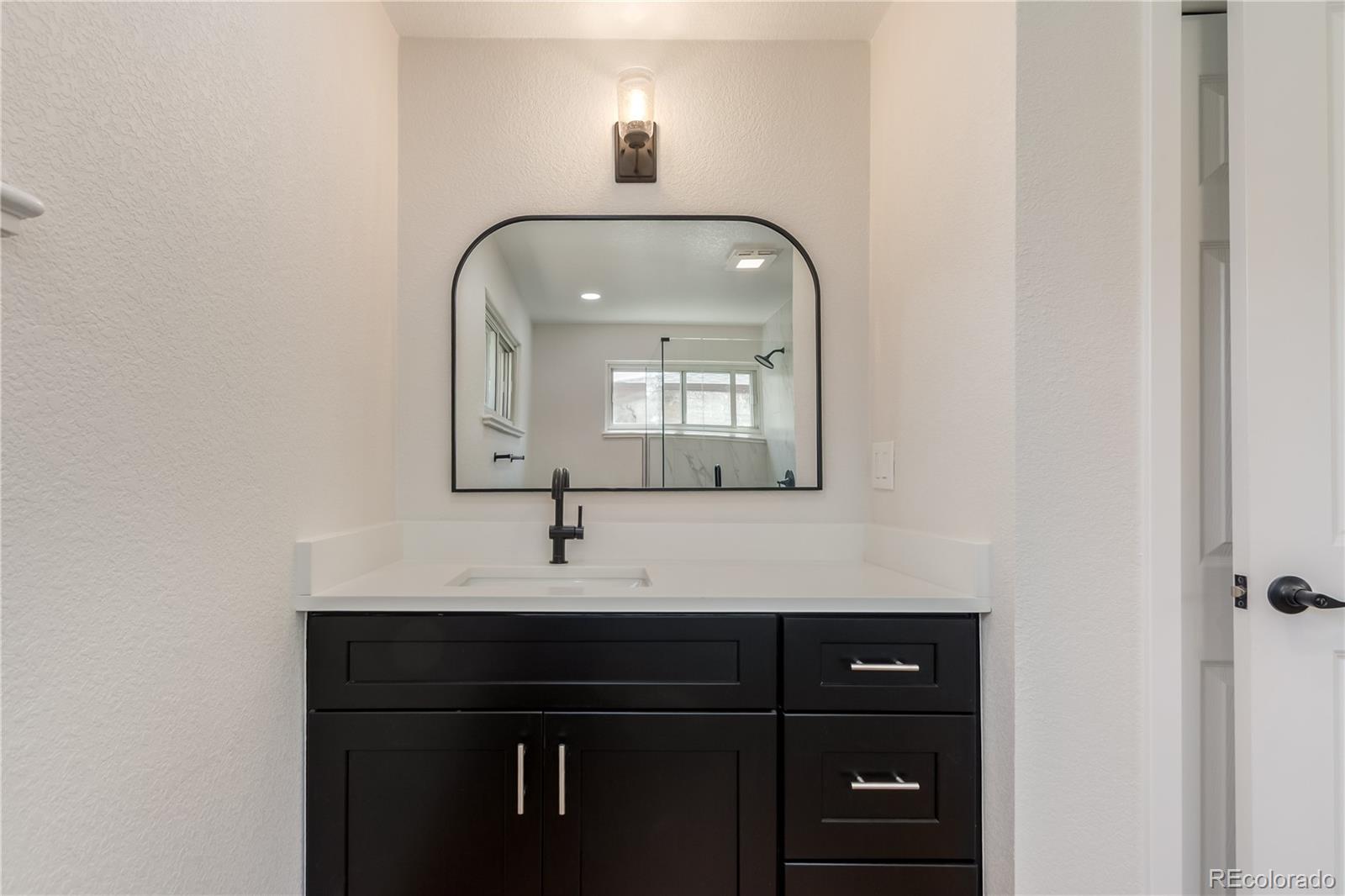 2702 Atchison Street Aurora, CO 80011 - Photo 12 of 18 a bathroom with a sink and a mirror