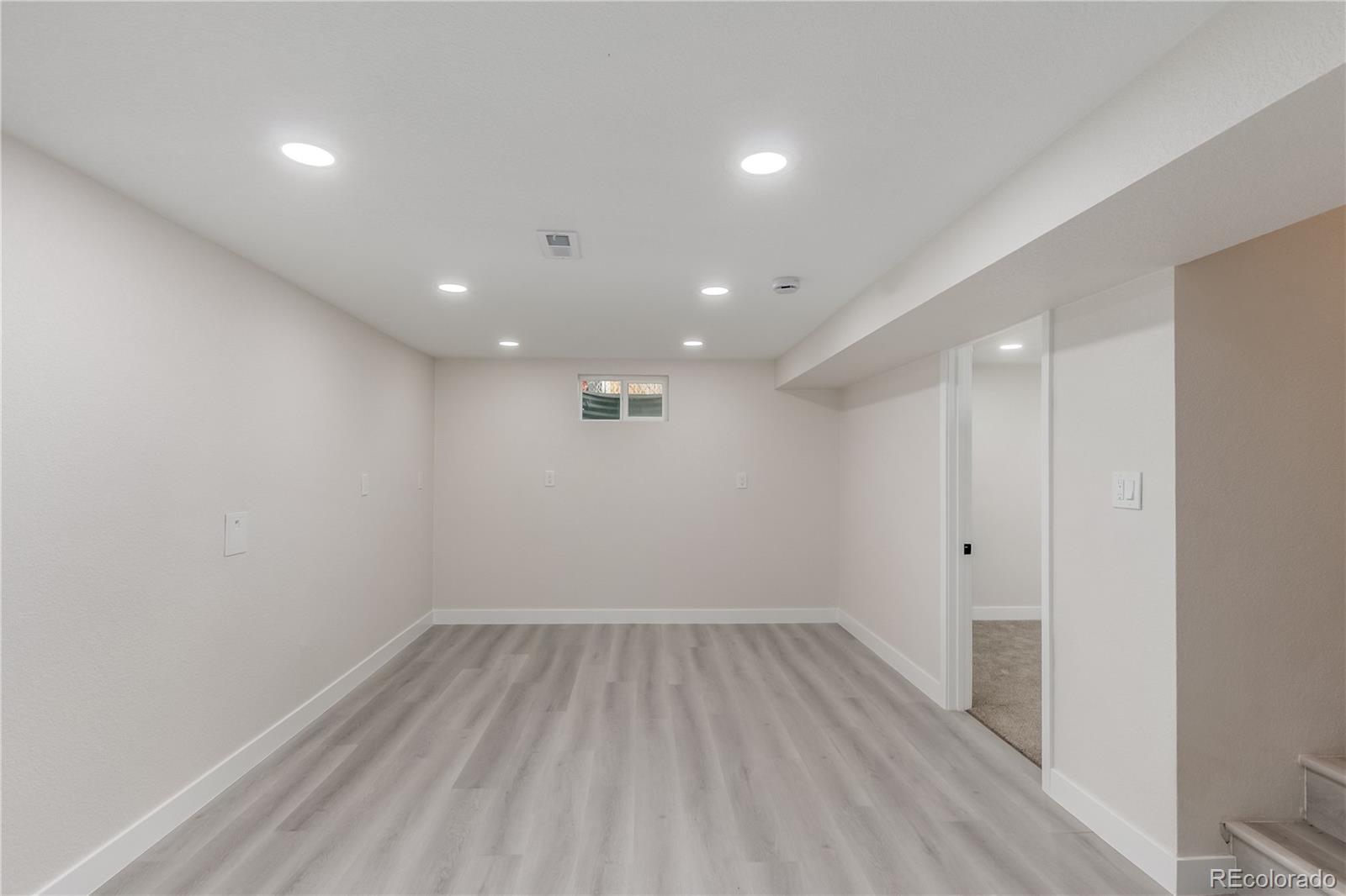 2702 Atchison Street Aurora, CO 80011 - Photo 14 of 18 a view of room with window and wooden floor