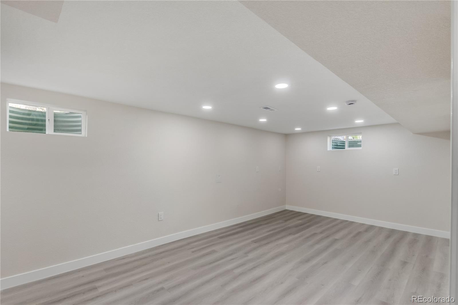 2702 Atchison Street Aurora, CO 80011 - Photo 17 of 18 an empty room with wooden floor and windows