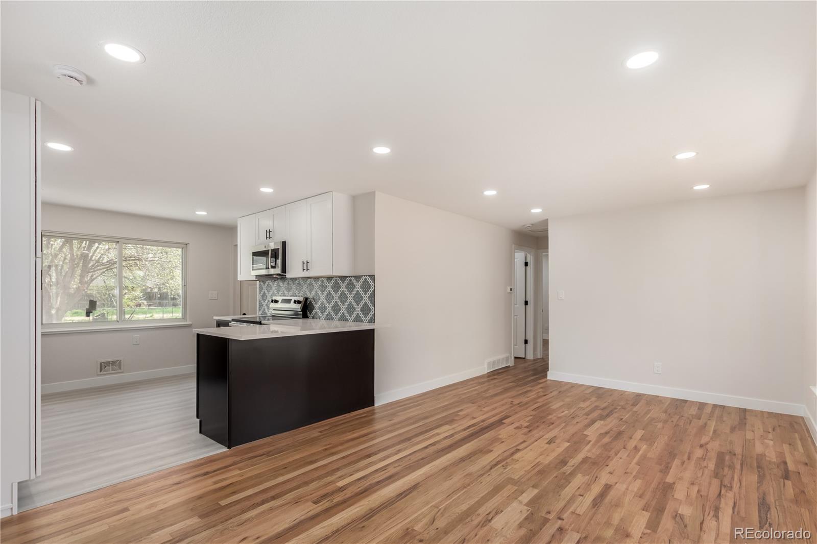 2702 Atchison Street Aurora, CO 80011 - Photo 3 of 18 a view of kitchen with wooden floor and stainless steel appliances