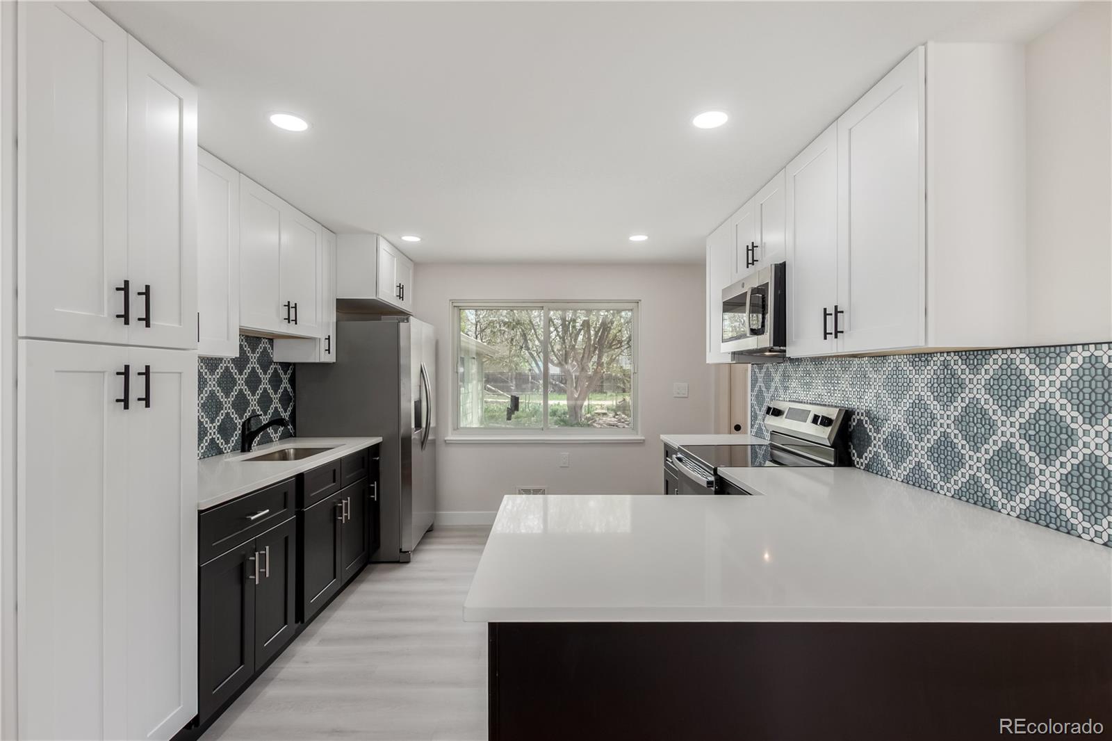 2702 Atchison Street Aurora, CO 80011 - Photo 6 of 18 a kitchen with stainless steel appliances a sink stove and refrigerator