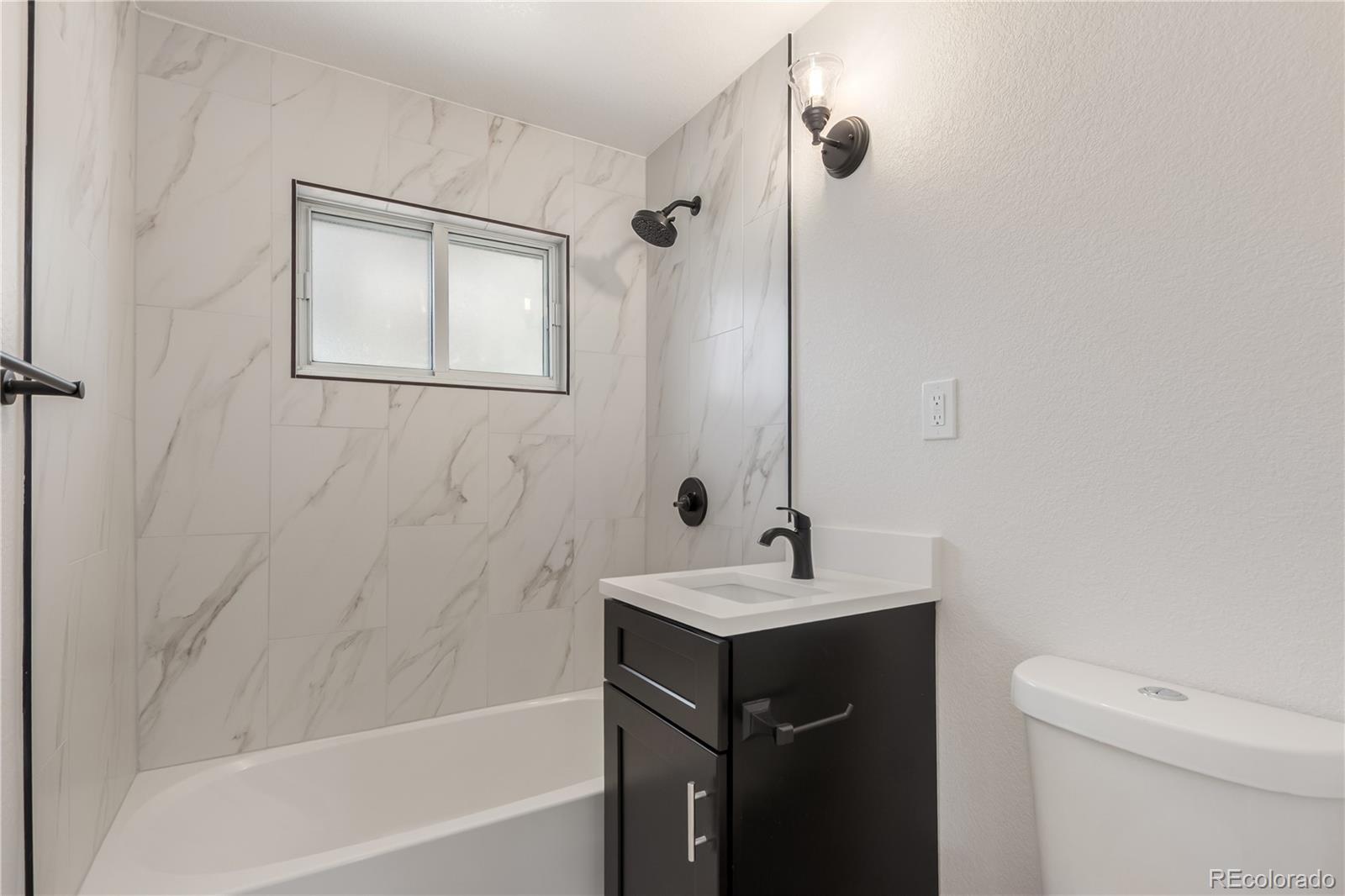 2702 Atchison Street Aurora, CO 80011 - Photo 9 of 18 a bathroom with a sink a toilet and shower