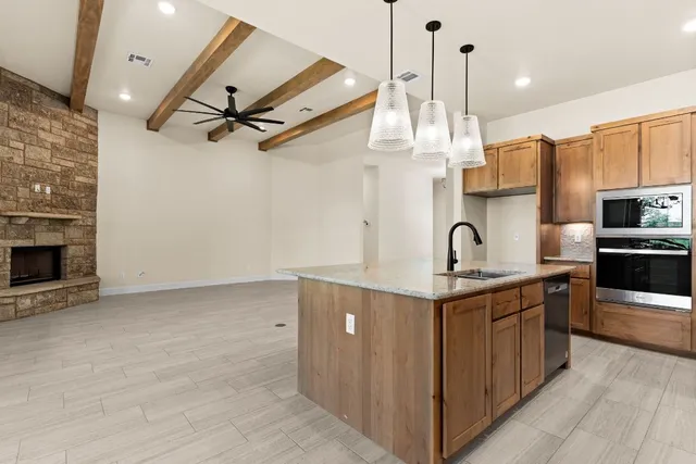 a kitchen with stainless steel appliances granite countertop a sink a stove and a refrigerator
