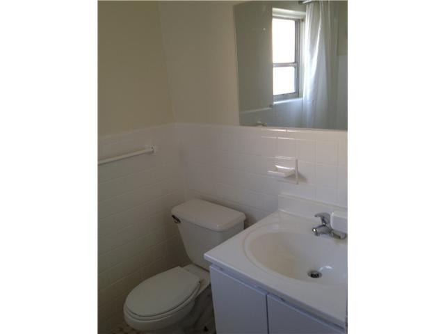 519 North Birch Road, Unit 12 Fort Lauderdale, FL 33304 - Photo 8 of 9 a white toilet sitting next to a bathroom sink