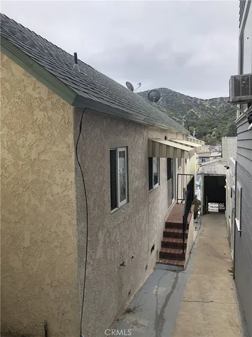 a backyard of a house with barbeque oven and outdoor seating