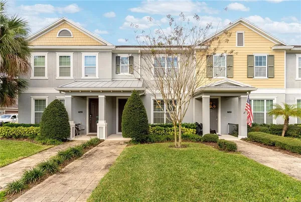 a front view of a house with a yard and trees