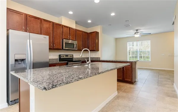a kitchen with stainless steel appliances granite countertop a sink refrigerator and microwave