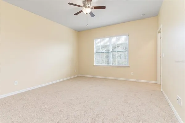 an empty room with a window and a fan