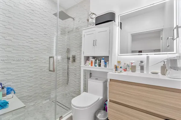 a bathroom with a toilet sink vanity and shower
